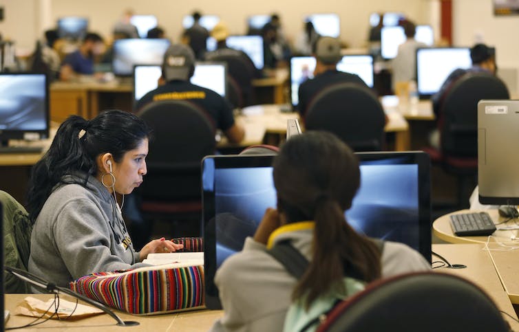 a roomful of people work on computers