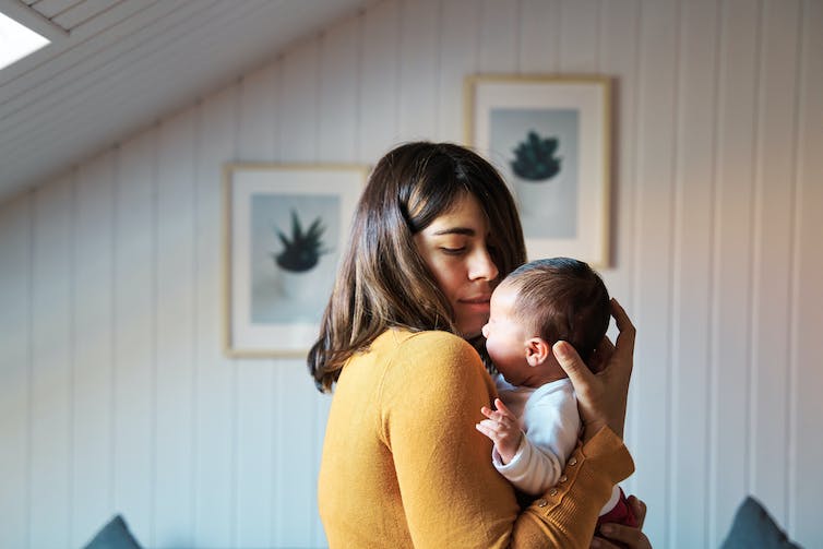 Person holding baby closely