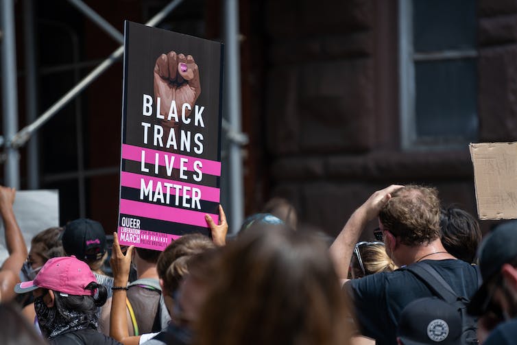 A demonstrator holds a sign a that supports Black transsexuals.