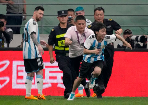 Lionel Messi scores, gets hugged by a fan during Argentina's 2-0 win over Australia