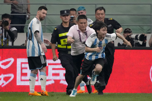 Lionel Messi scores, gets hugged by a fan during Argentina's 2-0 win over Australia