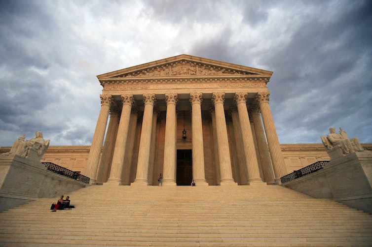 A large, columned white building at the top of a grand, white set of stairs.