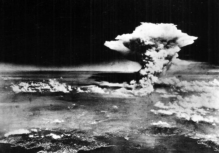 A black and white photo shows a massive cloud of smoke in the air.