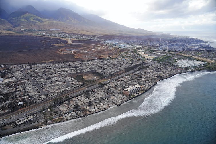 A view of the burned city, with few houses remaining. Smoke is still evident in some areas.