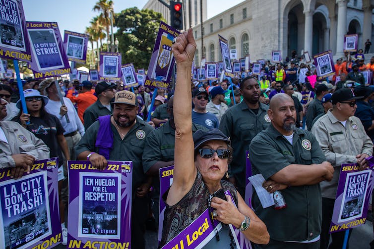 Workers at a rally carrying strike signs.