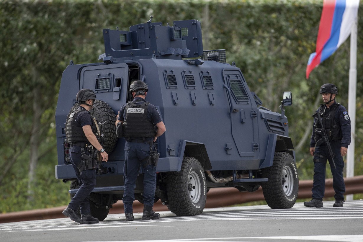 Kosovar police surround a village after Serb gunmen storm a monastery in violence that has killed 4