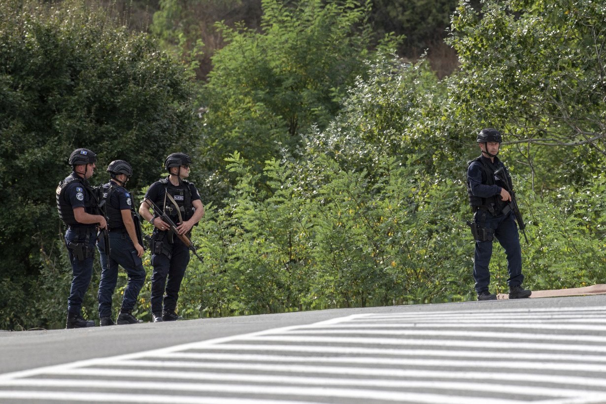 Kosovar police surround a village after Serb gunmen storm a monastery in violence that has killed 4