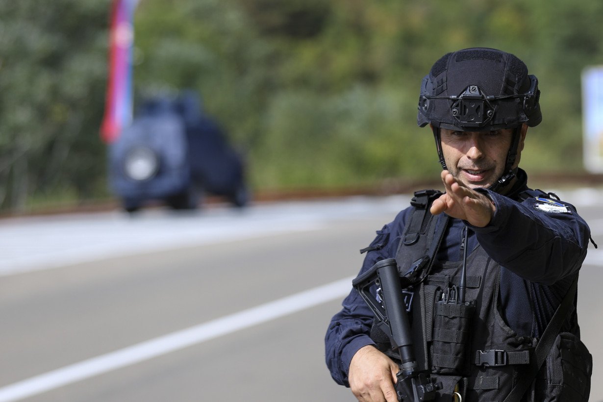 Kosovar police surround a village after Serb gunmen storm a monastery in violence that has killed 4