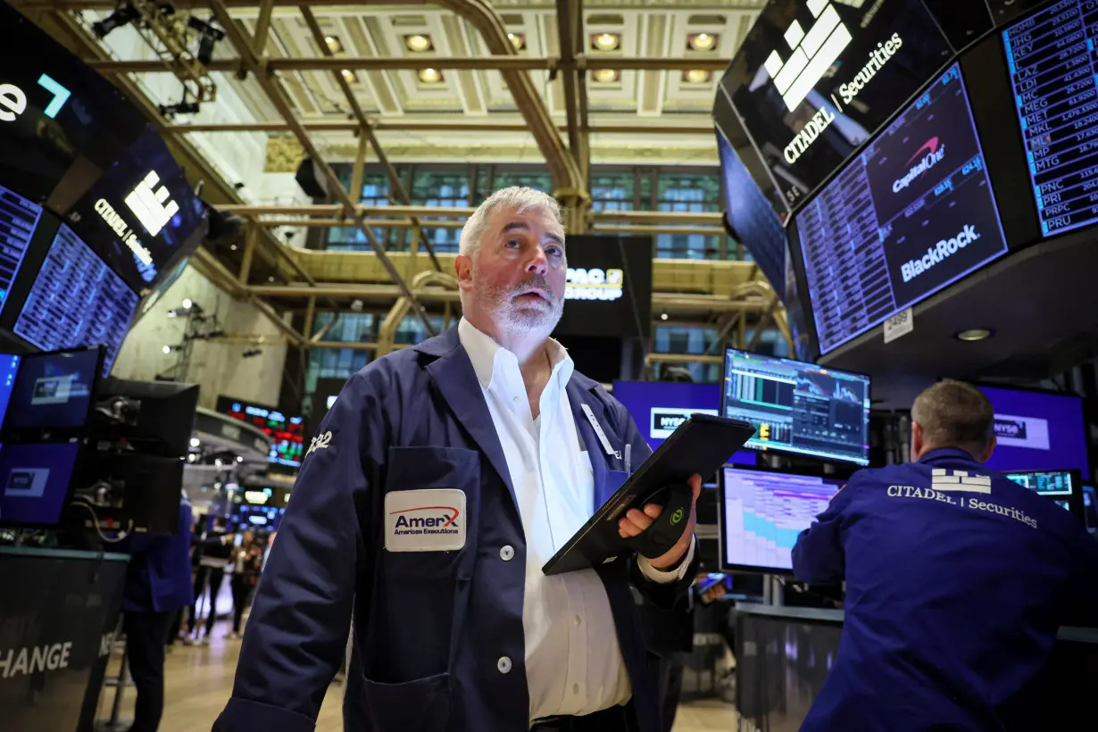 FILE PHOTO: Traders work on the floor of the NYSE in New York