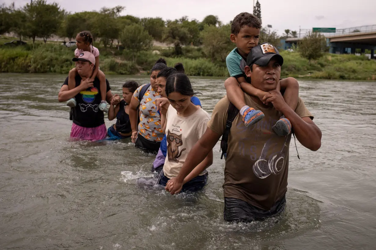 FILE PHOTO: Migrants wade into the U.S. in Eagle Pass, Texas