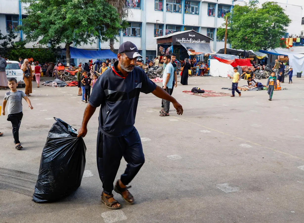 A Palestinian drags a garbage bag, amid the ongoing Israeli-Palestinian conflict in Khan Younis