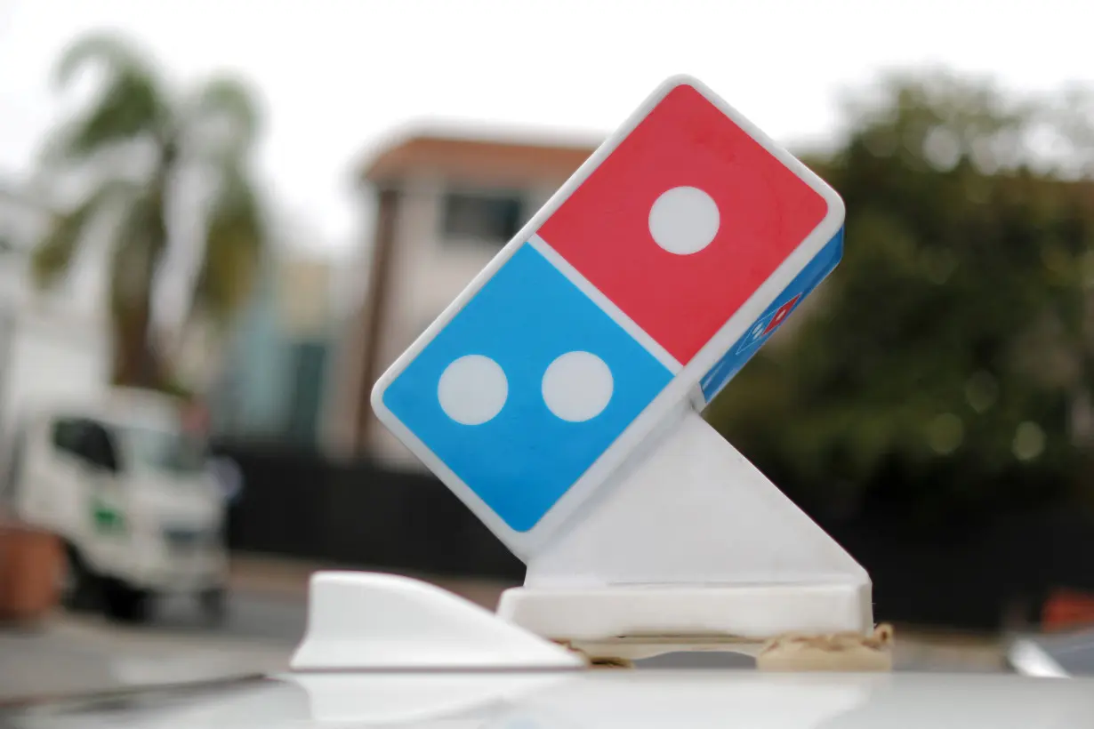 FILE PHOTO: A Domino's Pizza sign sits on the top of a delivery car outside a restaurant in Los Angeles