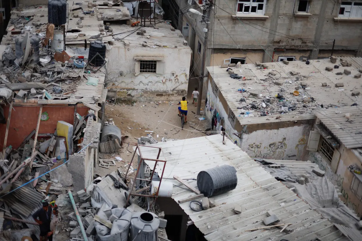 Emergency personnel and people check the damage at the site of Israeli strikes on houses in Khan Younis