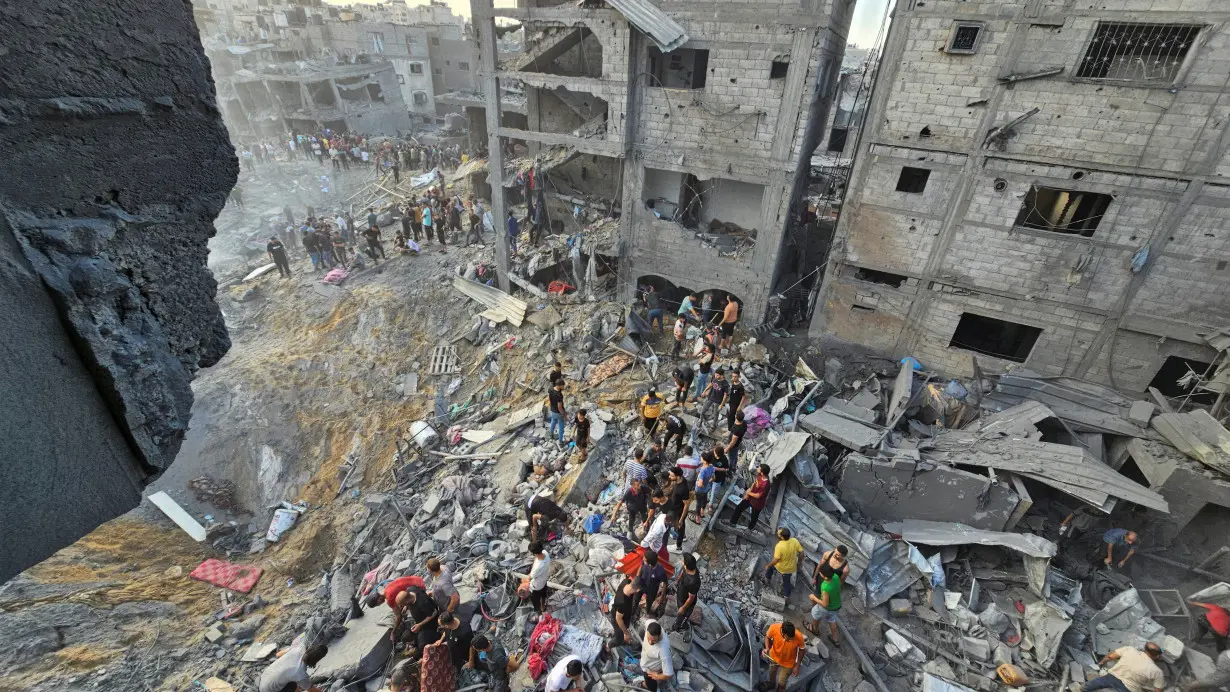 Palestinians search for casualties at the site of Israeli strikes on houses in Jabalia refugee camp