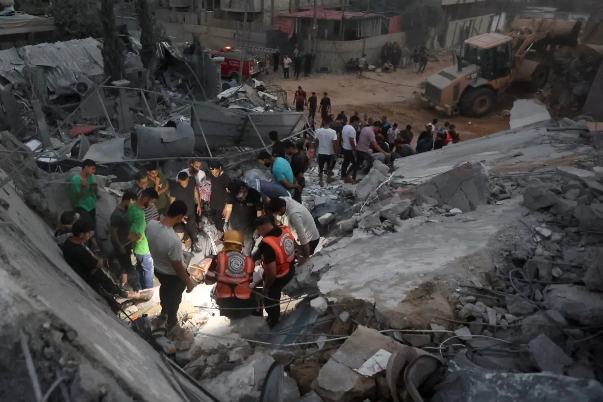 Palestinians search for casualties at the site of Israeli strikes on a residential building