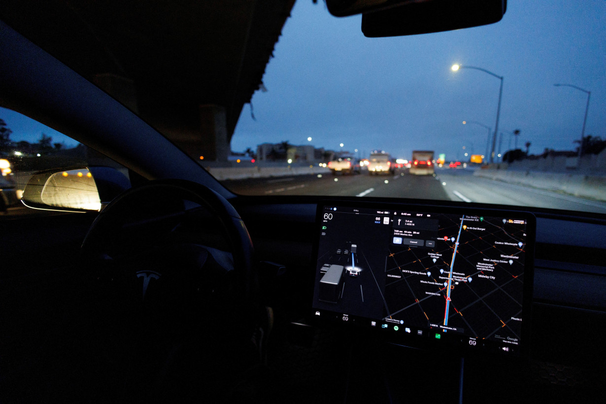 FILE PHOTO: Tesla Model 3 drives on autopilot along California freeway