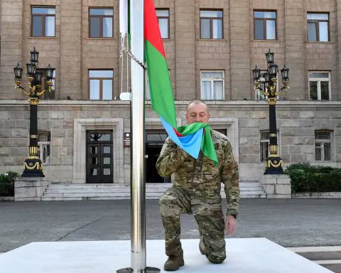 Azerbaijan's president raises the nation's flag in a former breakaway region's capital