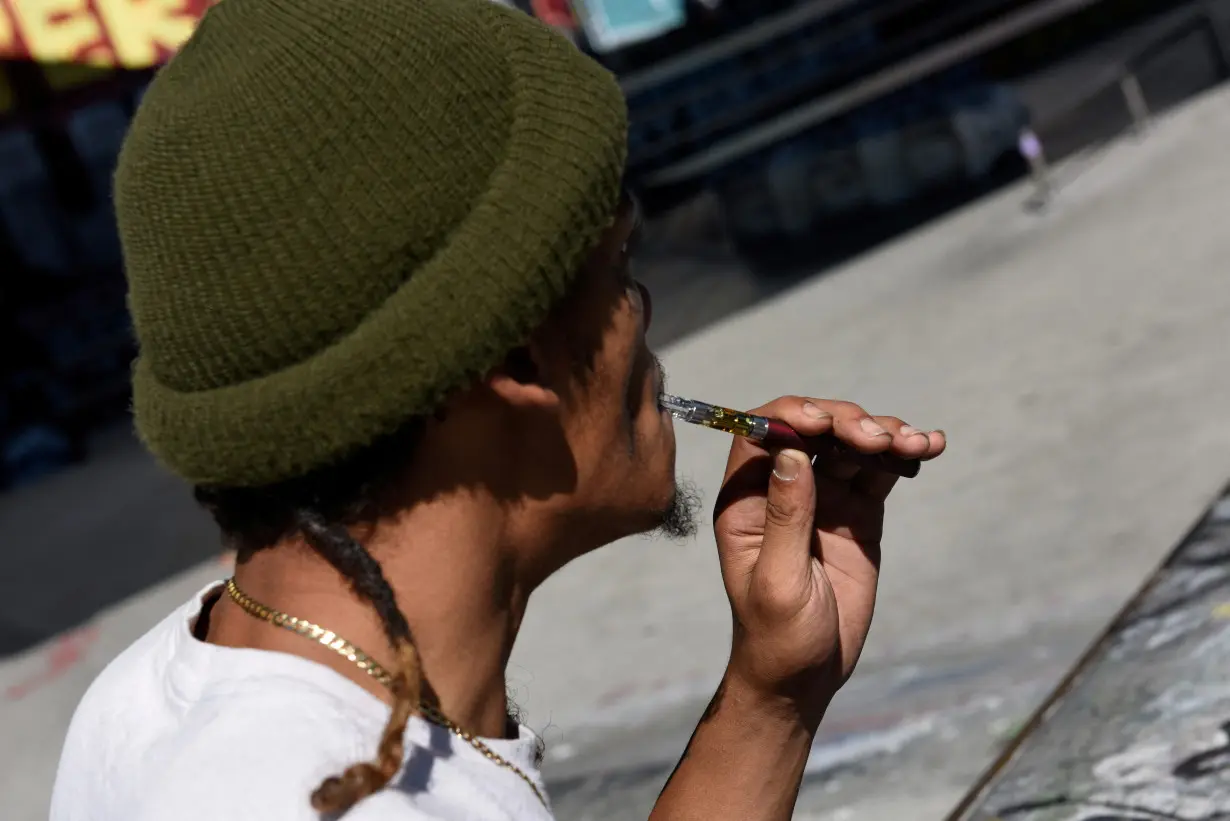 FILE PHOTO: A young man uses a vaping device at a skate park in San Francisco