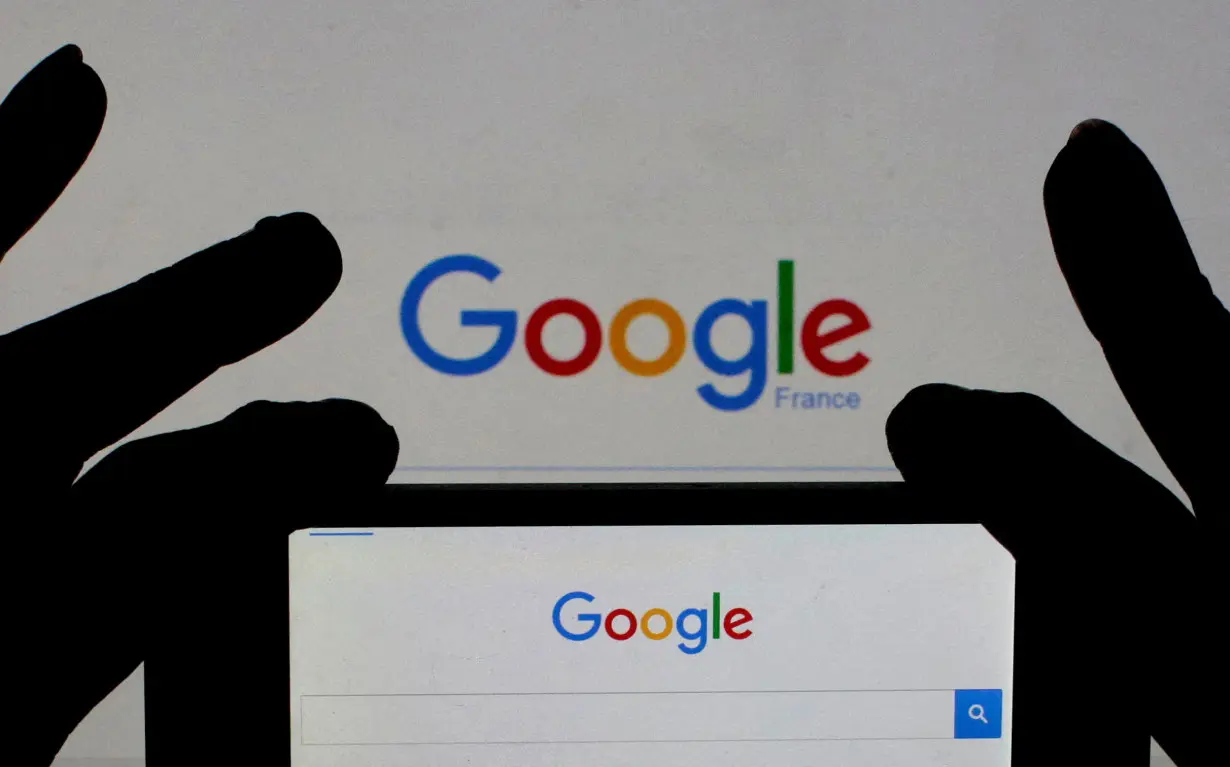 FILE PHOTO: Photo of a woman holding her smart phone which displays the Google home page, in this picture illustration