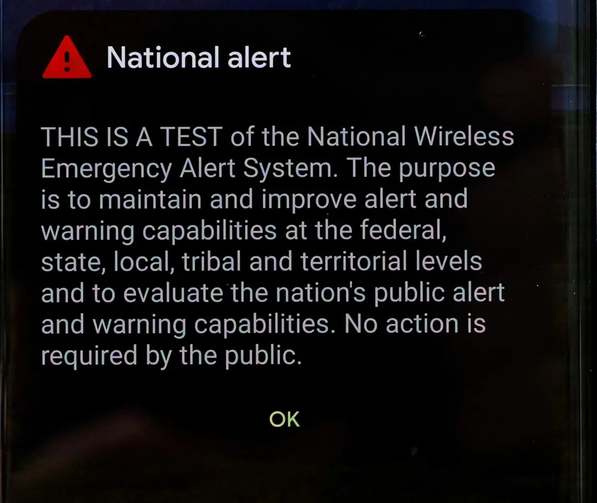 A National Alert is displayed on a phone from the National Wireless Emergency Alert System in New York
