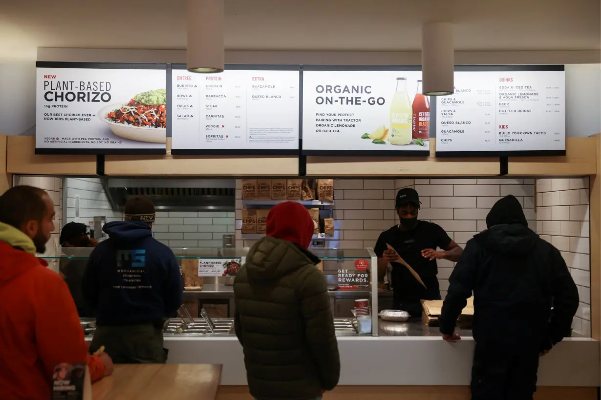 People are served in a Chipotle outlet in Manhattan, New York City