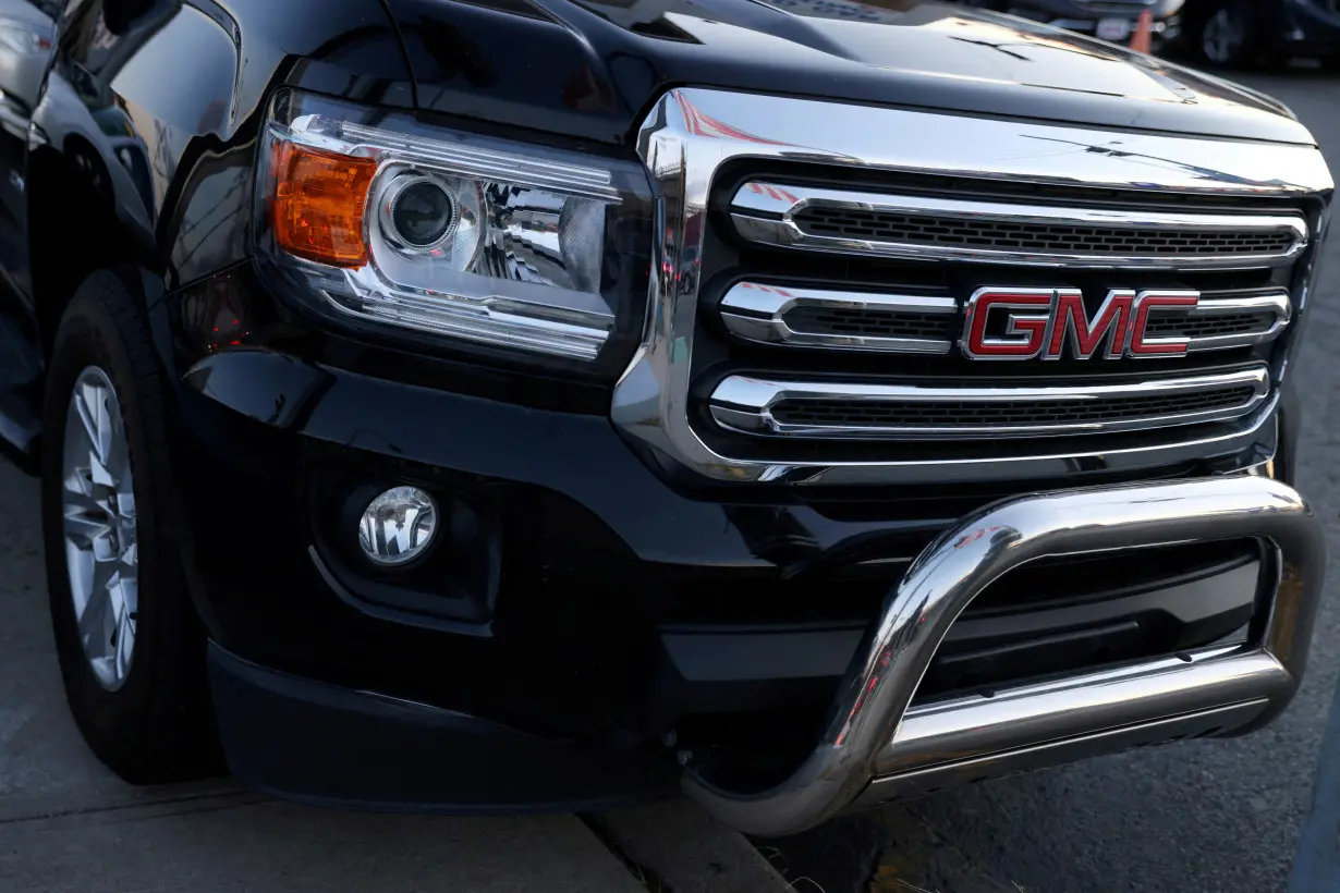 FILE PHOTO: A badge of GMC, an automobile brand owned by General Motors Company, is seen on the grill of a vehicle for sale at a car dealership in Queens, New York