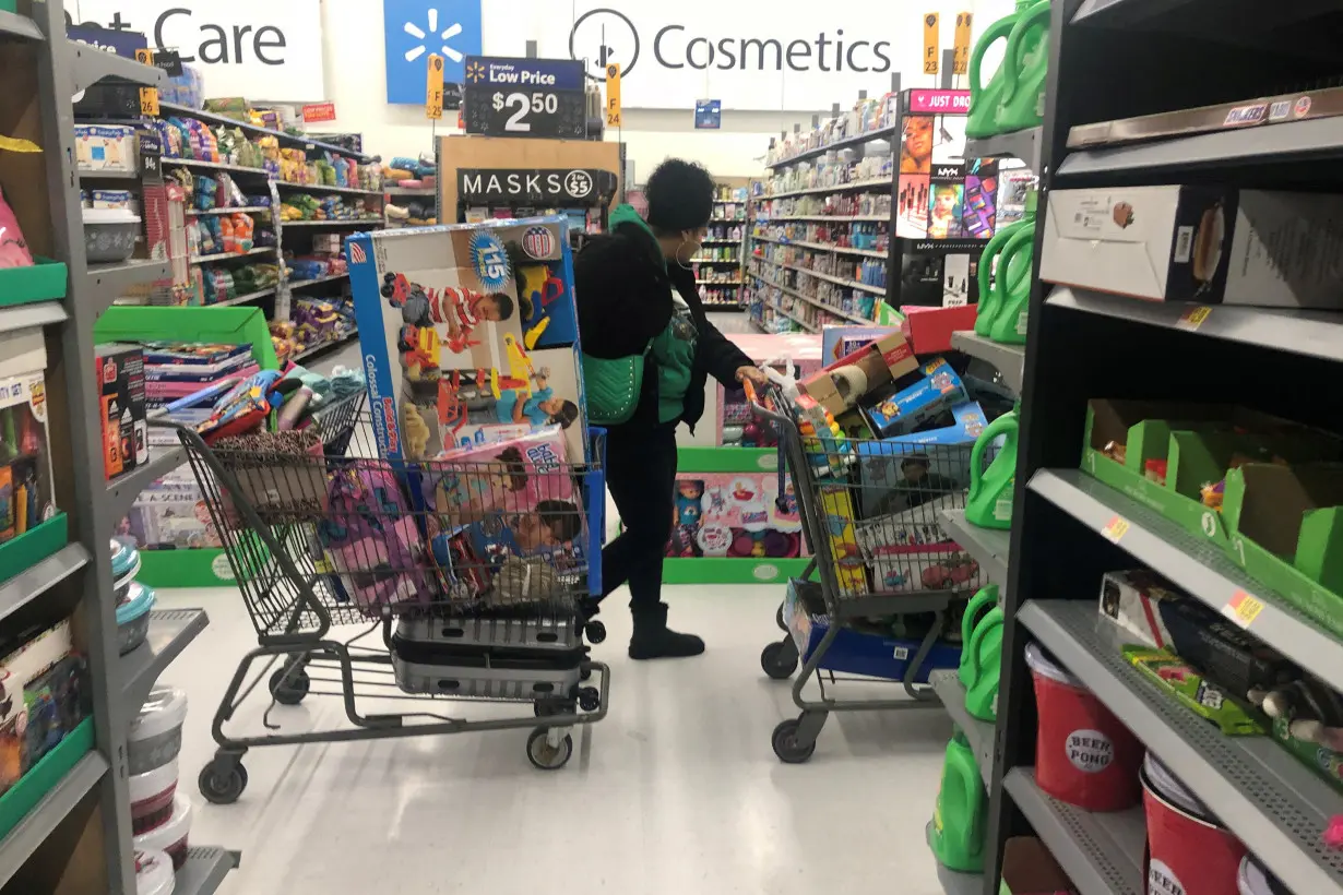 FILE PHOTO: A woman pushes shopping carts during a sales event on Thanksgiving day at Walmart in Westbury, New York