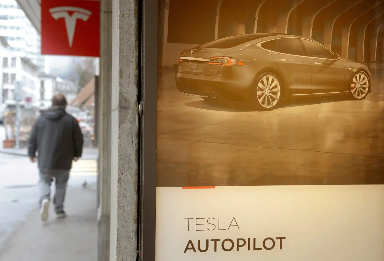 FILE PHOTO: Advertisement promotes Tesla Autopilot at a showroom of U.S. car manufacturer Tesla in Zurich