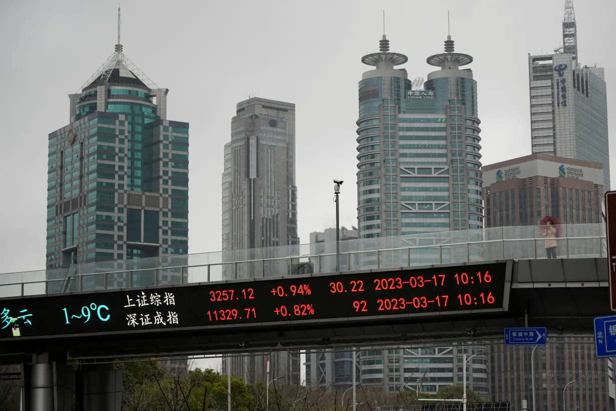 FILE PHOTO: An electronic board shows Shanghai and Shenzhen stock indices at the Lujiazui financial district in Shanghai