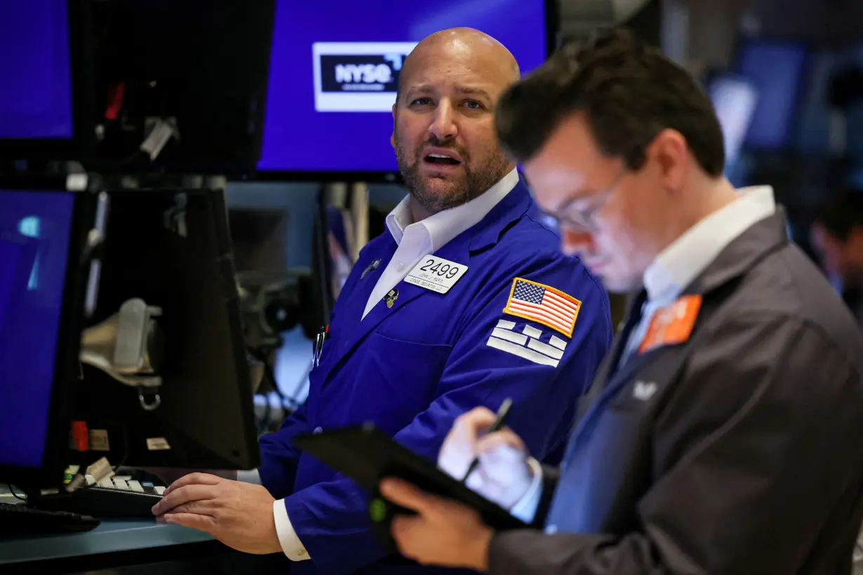 FILE PHOTO: Traders work on the floor of the NYSE in New York