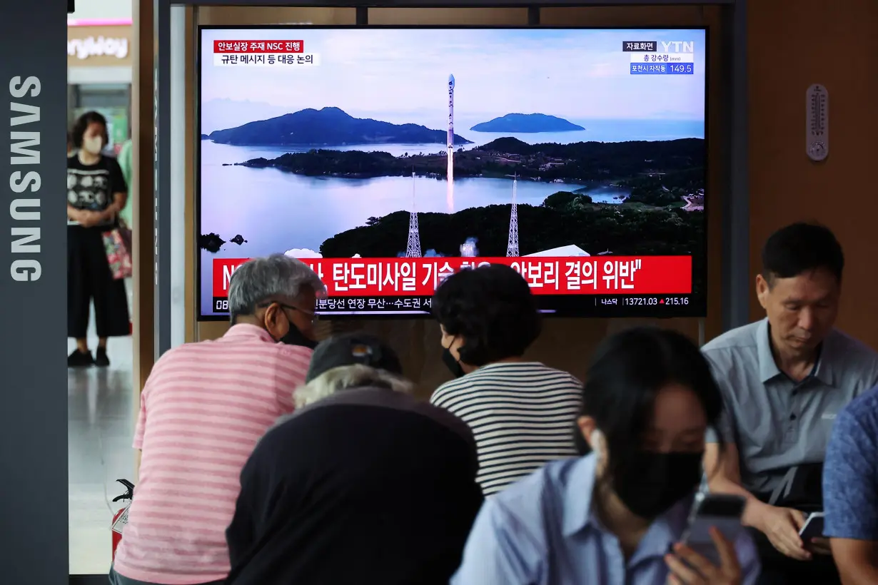 FILE PHOTO: TV broadcasting a news report on North Korea firing a space rocket, at a railway station in Seoul