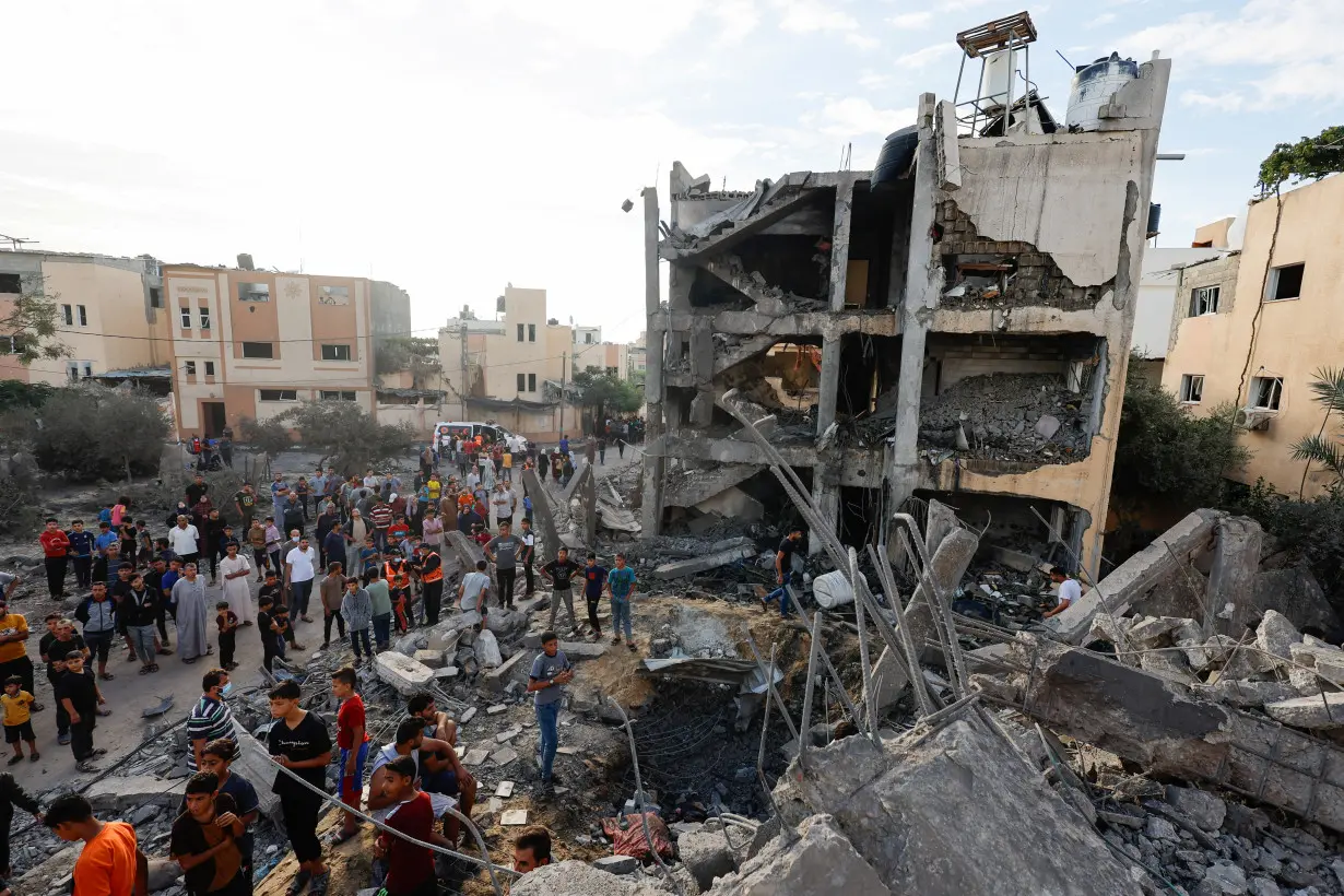 Palestinians search for casualties under the rubble of a building destroyed by Israeli strikes in Khan Younis