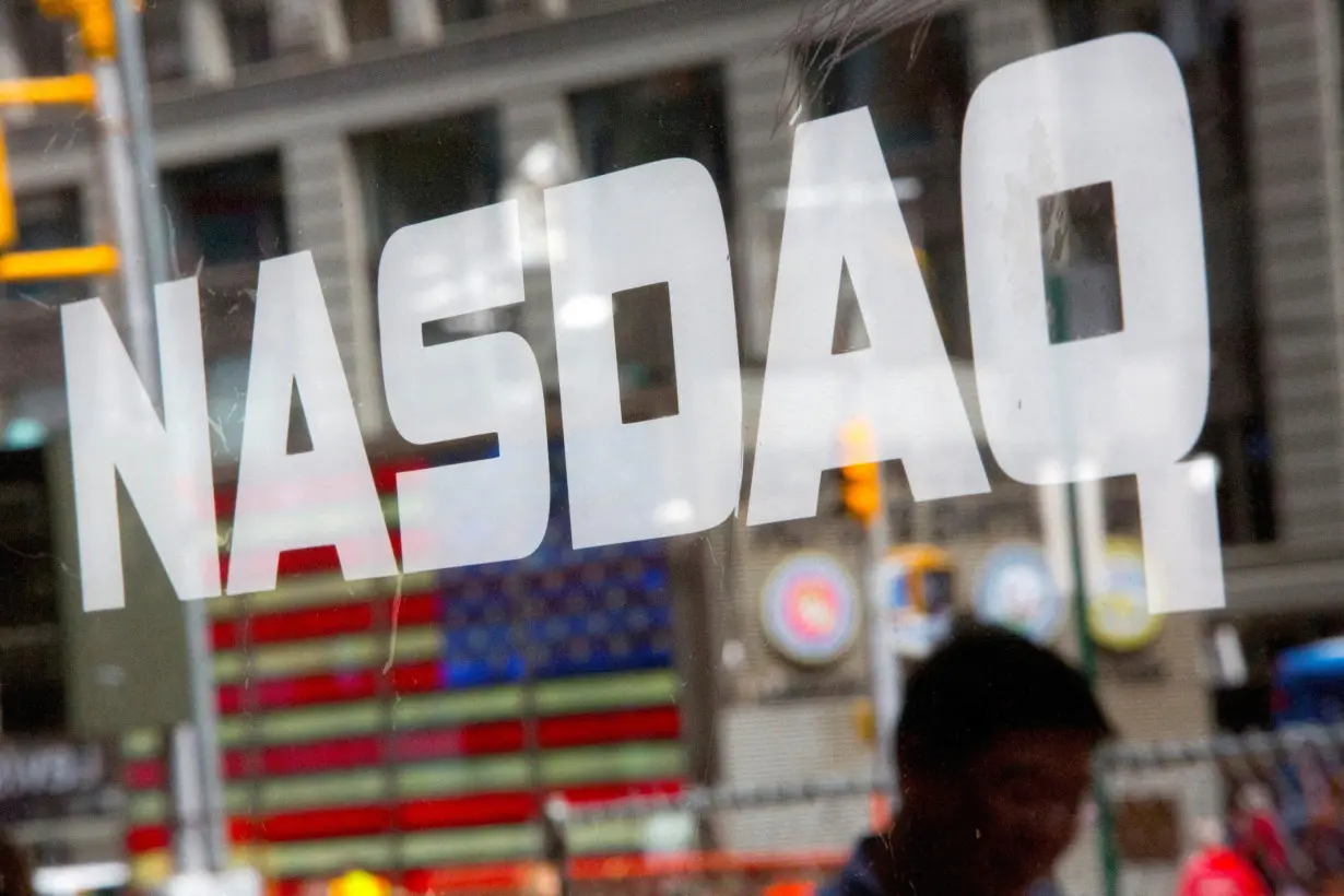 FILE PHOTO: A man walks past the Nasdaq MarketSite in New York's Times Square, August 23, 2013. REUTERS/Andrew Kelly