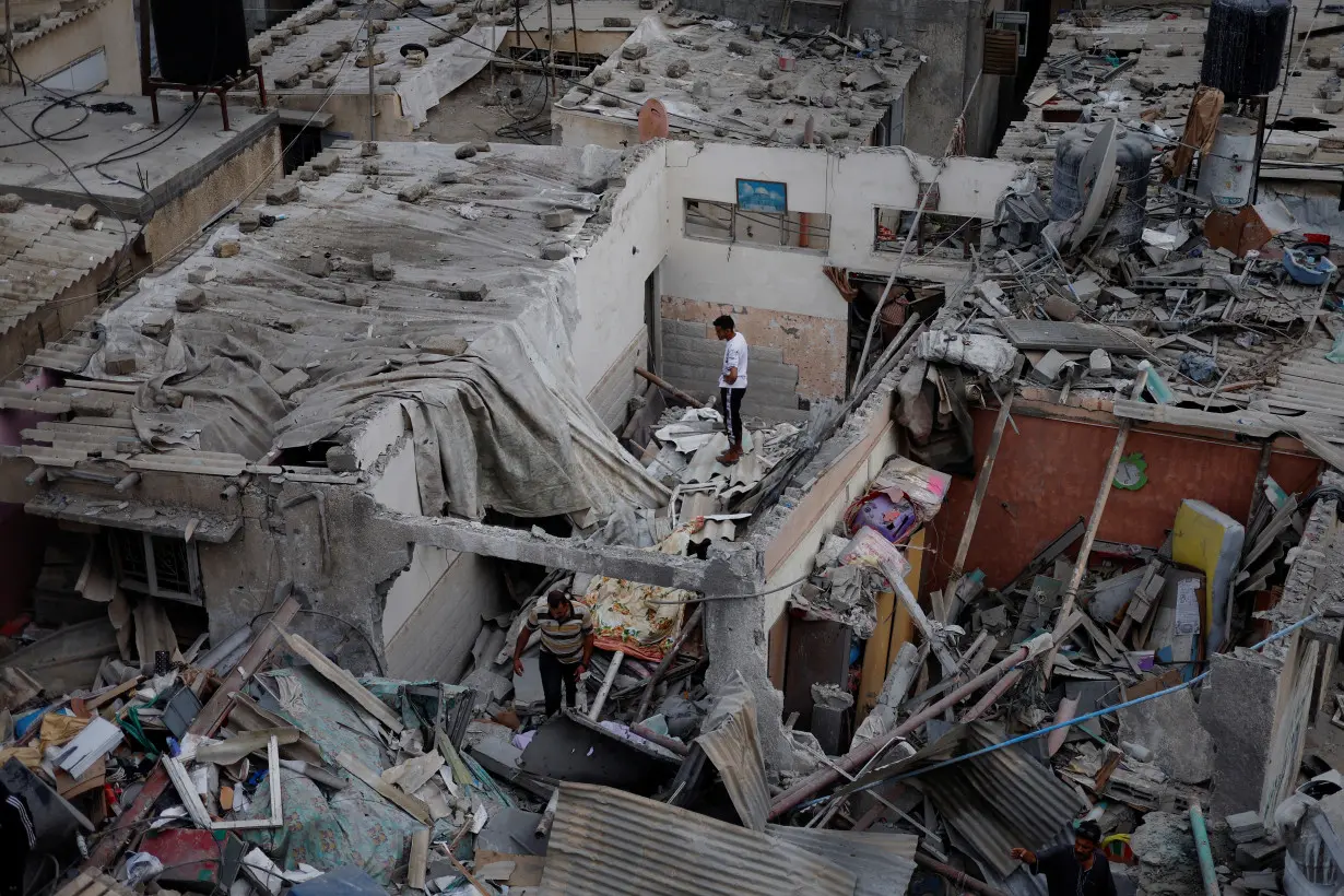 Palestinians check the damage at the site of Israeli strikes on houses in Khan Younis