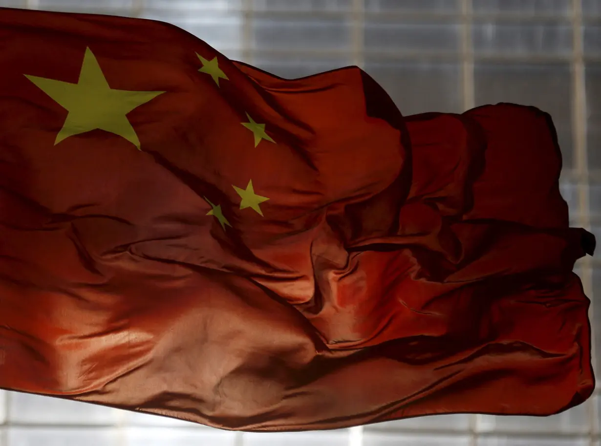 FILE PHOTO: China's national flag flutters at a business district in Beijing