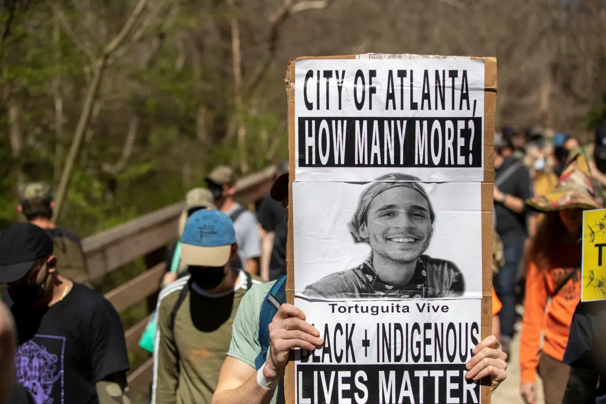 People protest against the building of an Atlanta public safety training facility during a Defend The Atlanta Forest march on the South River Trail in Atlanta