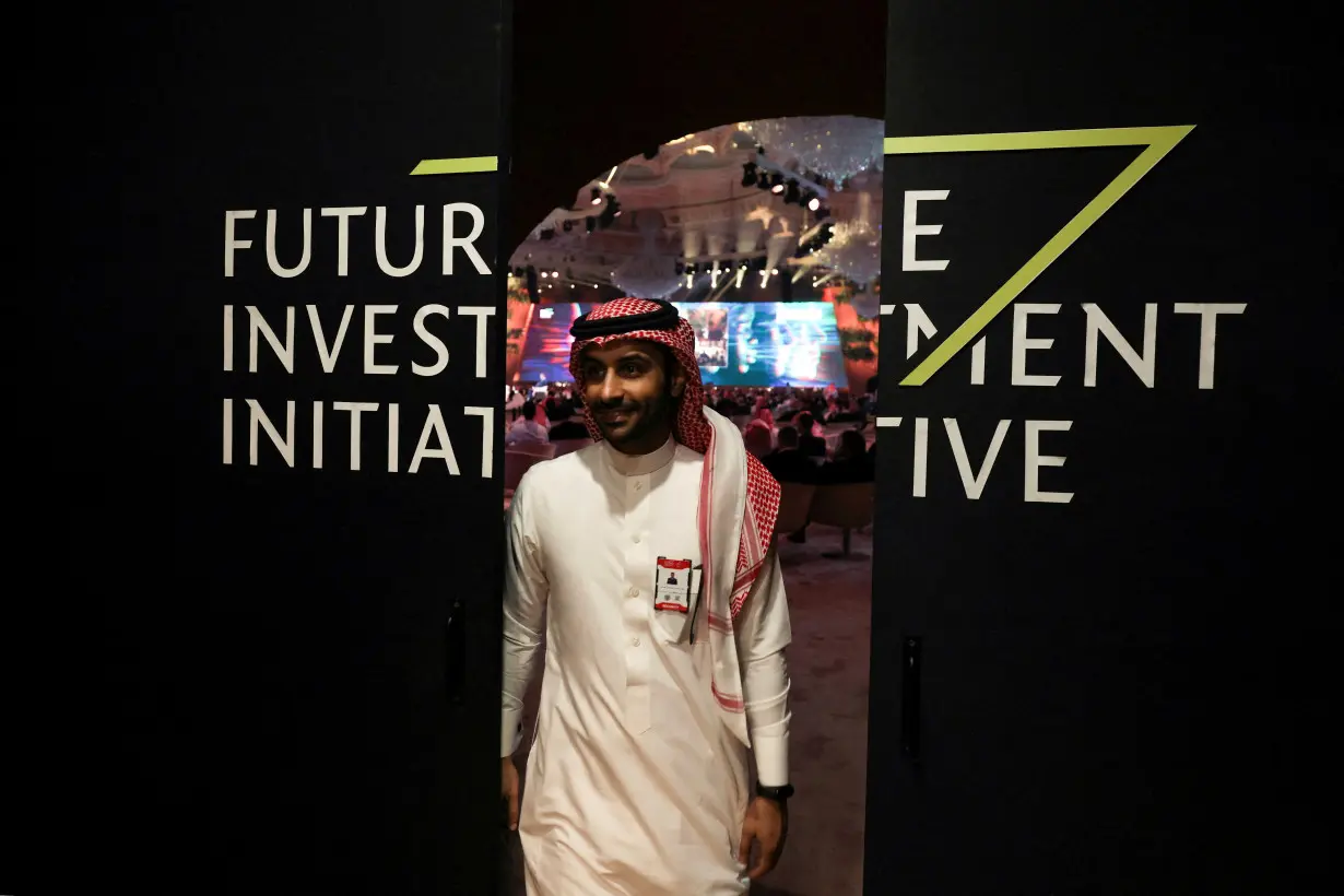 FILE PHOTO: A Saudi man's reflection is seen in mirror glass at the Future Investment Initiative conference, in Riyadh, Saudi Arabia