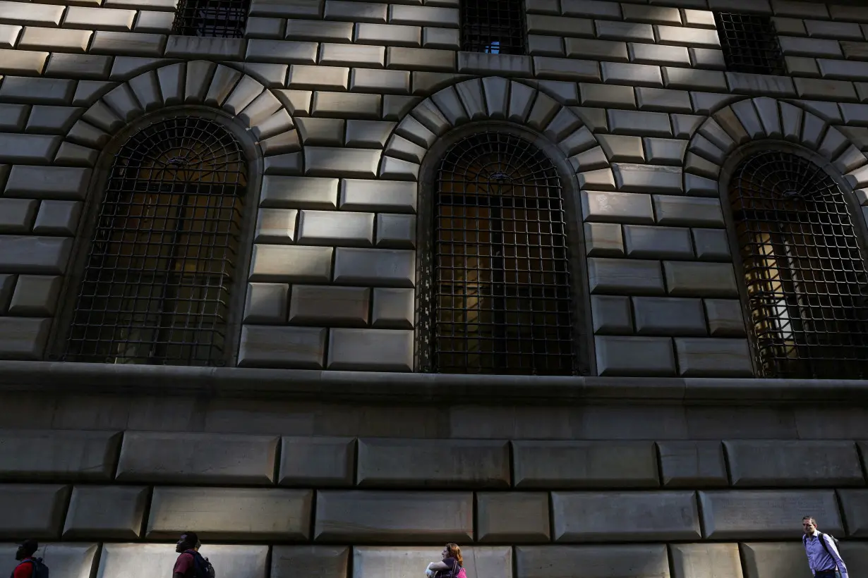 FILE PHOTO: People walk by the Federal Reserve Bank of New York in the financial district of New York City, U.S., June 14, 2023. REUTERS/Shannon Stapleton/