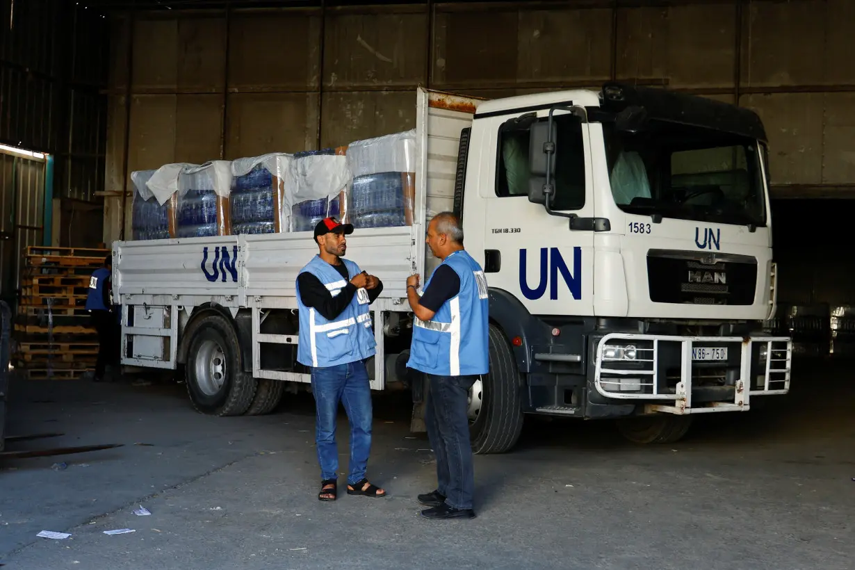 Workers sort aid to be distributed to Palestinians, at a United Nations-run facility, in Khan Younis