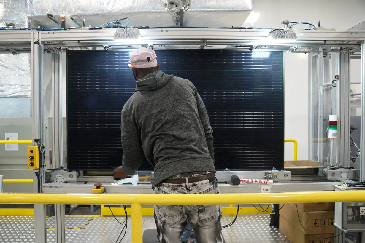 Employees work on solar panels at the QCells solar manufacturing factory in Dalton