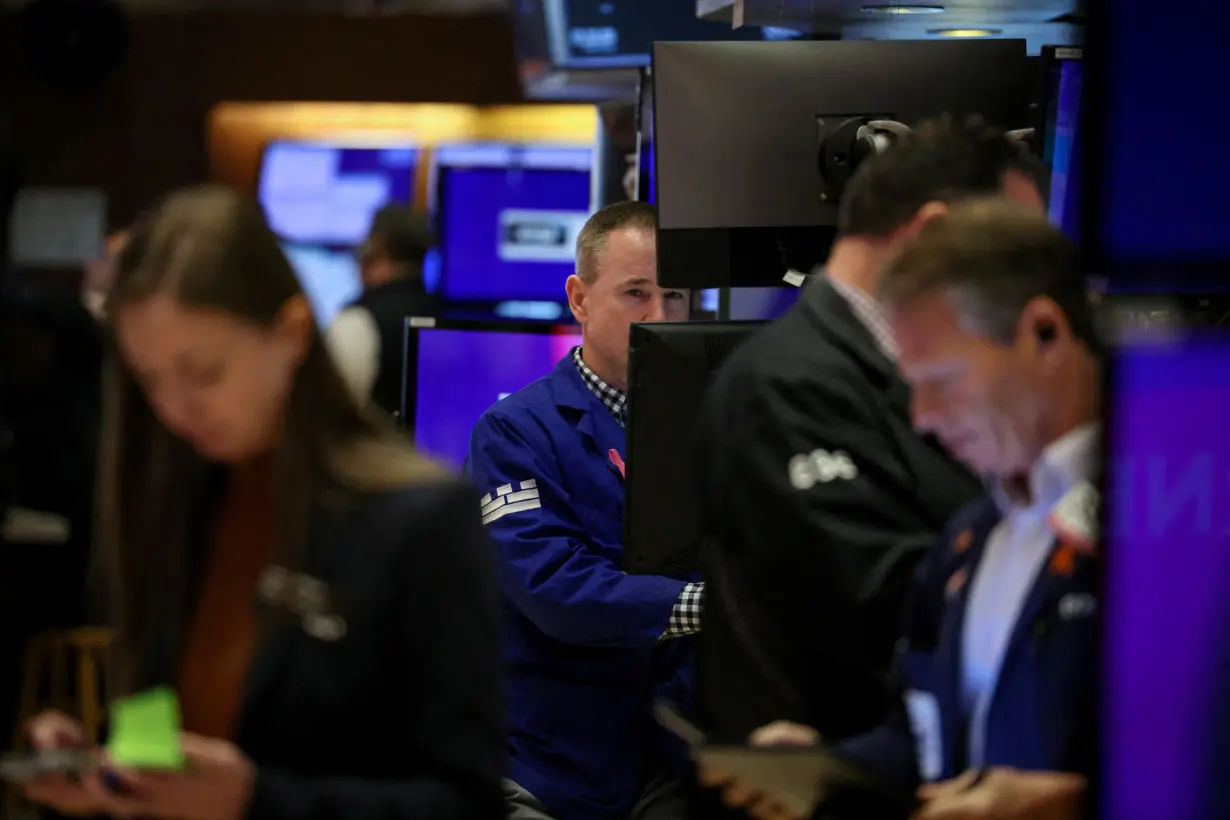 FILE PHOTO: Traders work on the floor of the NYSE in New York