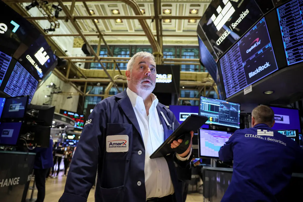 FILE PHOTO: Traders work on the floor of the NYSE in New York