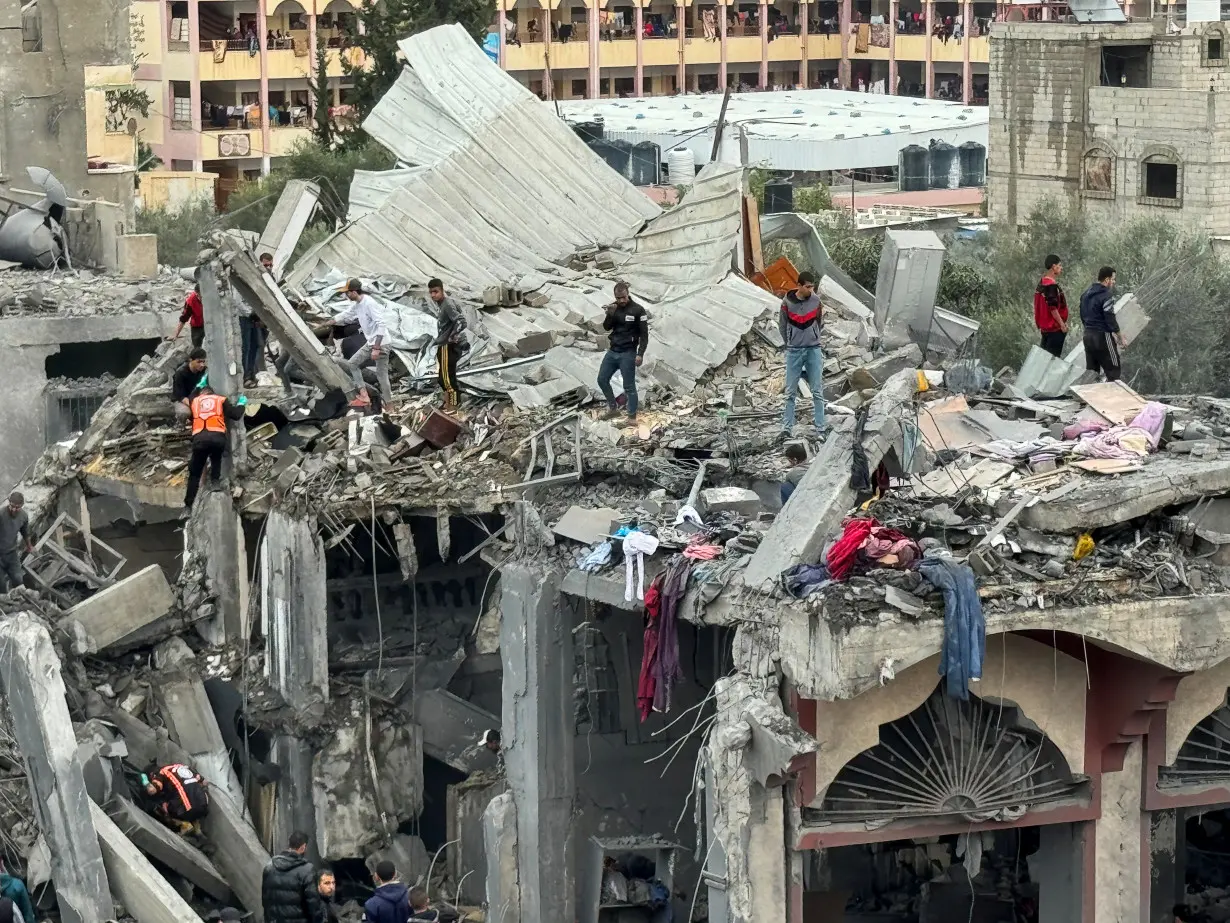 Palestinians search for casualties at the site of Israeli strikes on a house in Rafah