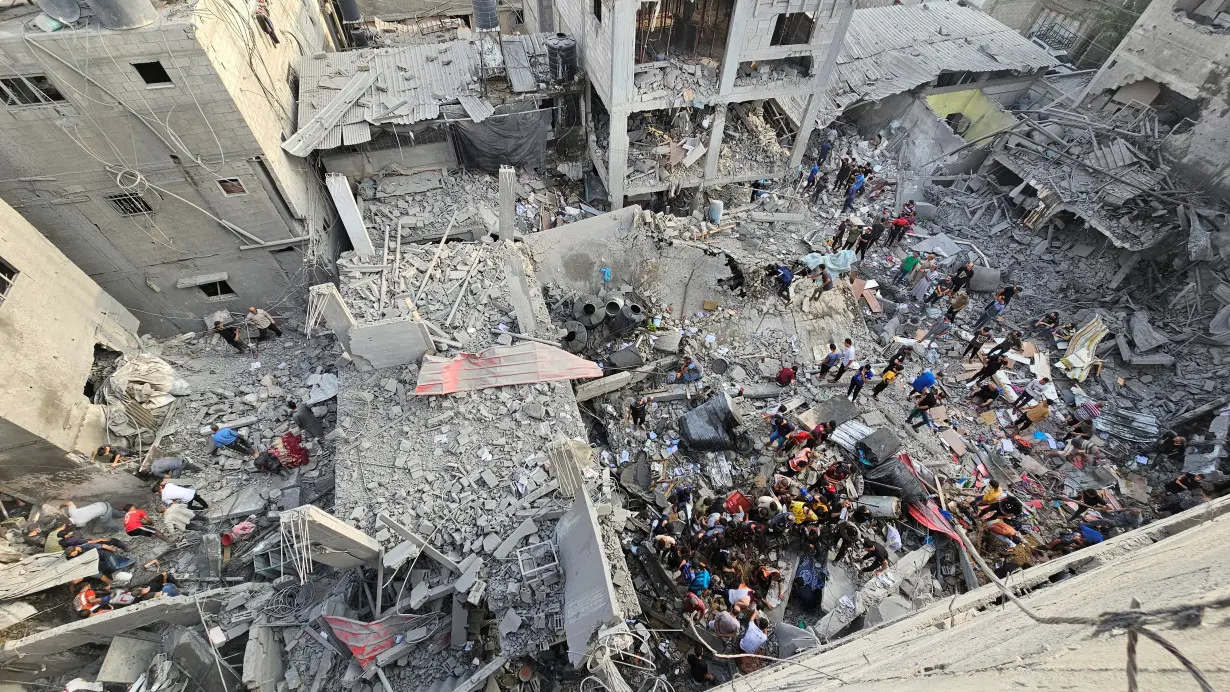 Palestinians search for casualties at the site of Israeli strikes on houses in Jabalia refugee camp