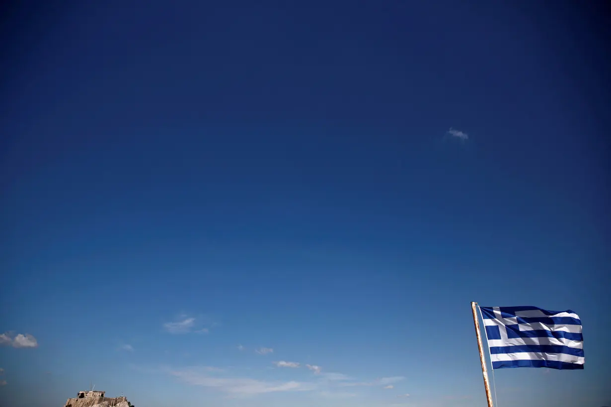 FILE PHOTO: A Greek flag flutters atop the Panathenean stadium as the Acropolis hill is seen in the background in Athens
