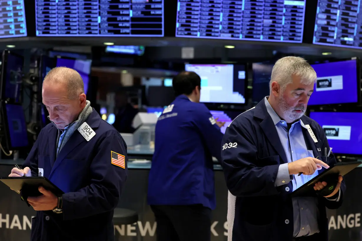 FILE PHOTO: Traders work on the floor of the NYSE in New York