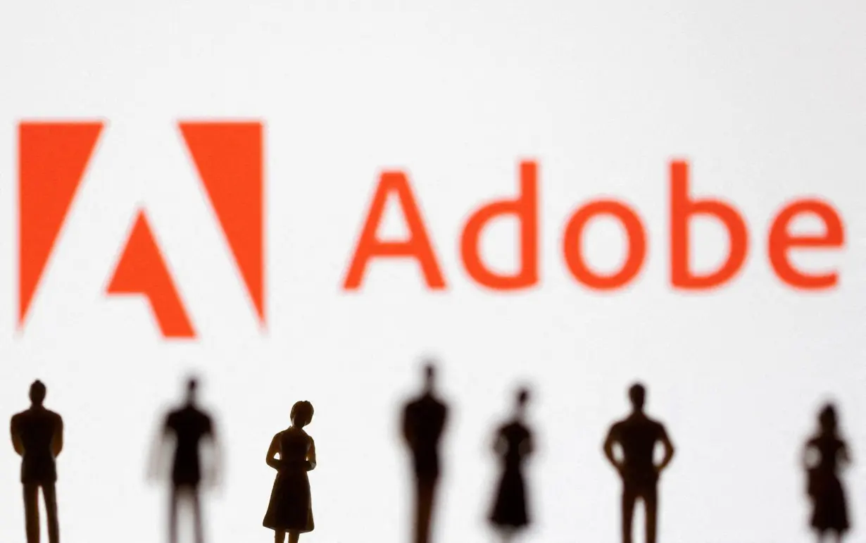 FILE PHOTO: Illustration shows figurines in front of Adobe logo