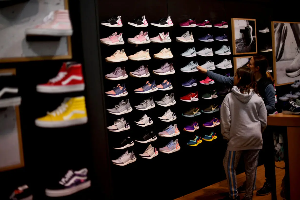 FILE PHOTO: Audrey Topkin, 11, selects sneakers with her mother, Robyn, at a Dick's Sporting Goods store as holiday shopping accelerates at the King of Prussia Mall