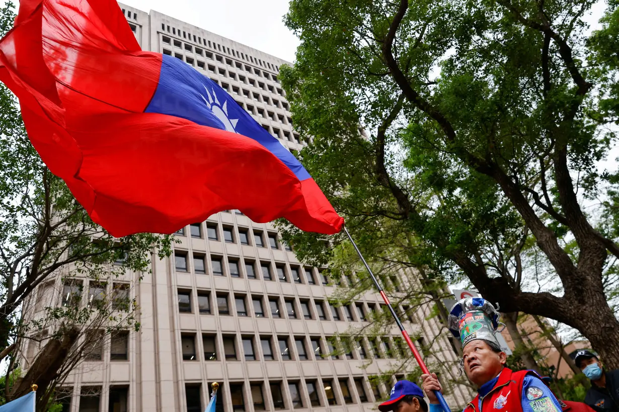 FILE PHOTO: A supporter of the main opposition party Kuomintang (KMT) waves a Taiwanese flag outside of the Central Election Commission, in Taipei