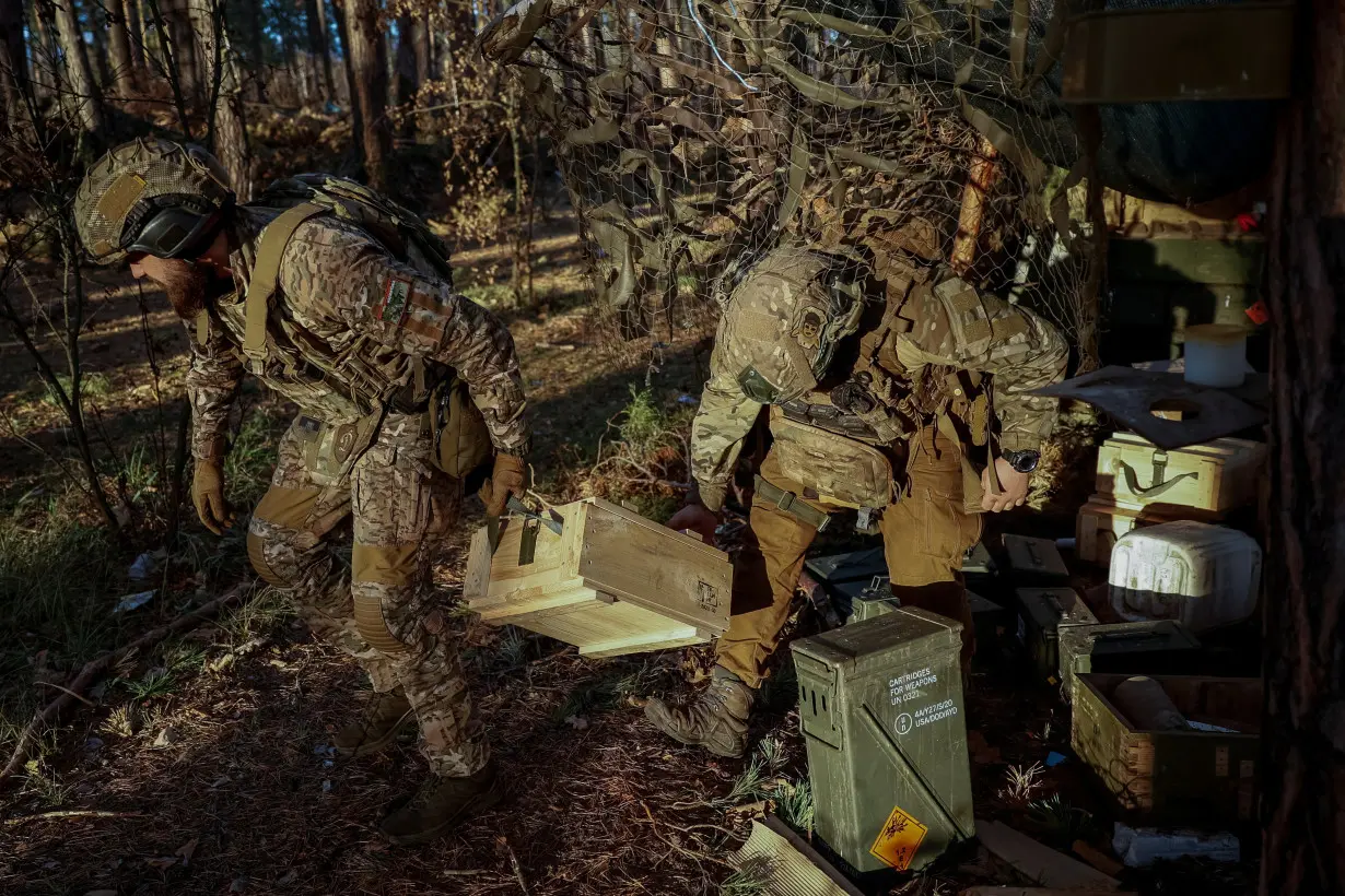 Servicemen of the 67th Mechanised Brigade carry a box with an ammunition to a position in a frontline near Kreminna, in Luhansk region